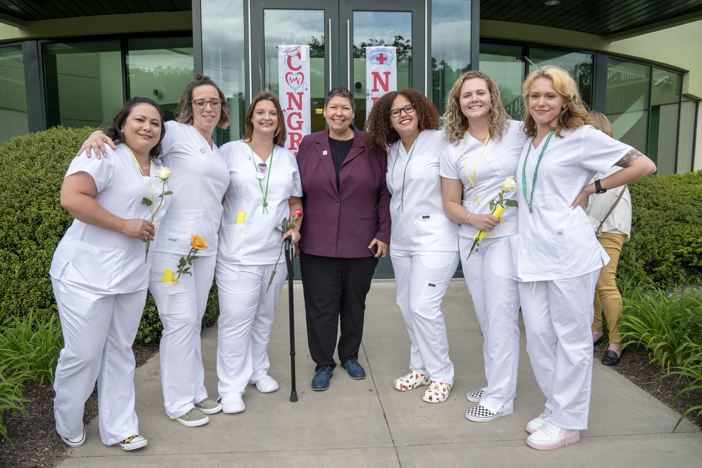 Christina Royal poses with a group of nurses in white scrubs